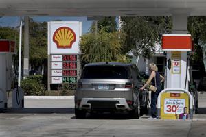 The price per gallon of gas is shown on a sign as a customer gets fuel at a station on March 9, 2026, in Miami. A barrel of oil passed the $100 mark for the first time in four years since Russia invaded Ukraine. (Joe Raedle/Getty Images/TNS)