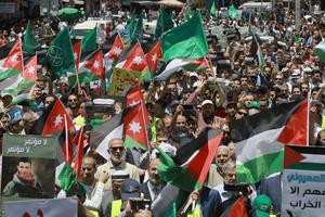 Flags of Jordan and the Muslim Brotherhood are waved with other protest signs denouncing the US-led Middle East economic conference in Bahrain, during a post-Friday prayers demonstration against US President Donald Trump's 