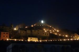 The dramatic finale of Cantiano's Passion Play leaves the center cross atop the town empty, save for a floodlit shroud blowing in the wind. (Rick Steves, Rick Steves' Europe)
