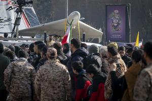 Revolutionary Guard personnel stand under an Iranian-made unmanned aerial vehicle, the Shahed-136, while participating in a military rally in Tehran, Iran, on Jan. 10, 2025.  Morteza Nikoubazl/NurPhoto via Getty Images