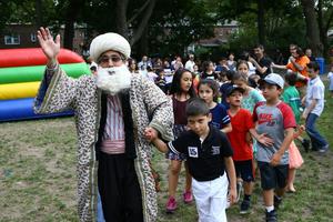 A man wearing a Nasreddin Hoja costume poses with children during Eid al-Fitr at Sunnyside Gardens Park in New York. Volkan Furuncu/Anadolu via Getty Images