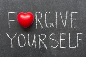 Forgive yourself phrase handwritten on school blackboard. Dreamstime/TCA