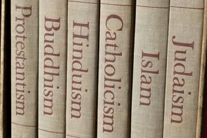 Book spines listing major world religions - Judaism, Islam, Catholicism, Hinduism, Buddhism and Protestantism. Dreamstime/TCA
