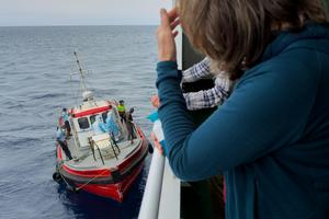 Passengers on the the hantavirus-stricken cruise ship MV Hondius watch epidemiologists board the boat in Praia, Cape Verde, on May 6, 2026 AP Photo/Uncredited