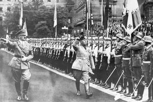 Hitler and Mussolini salute Nazi troops in 1937. Bettmann/Getty Images