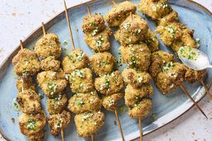 Skewers of marinated chicken are tossed with a combination of Italian breadcrumbs and Parmesan cheese, then drizzled with garlic butter sauce. (Alex Lepe/TCA)