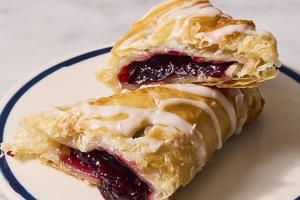 A sweet, jammy filling made with frozen cherries is surrounded by flaky puff pastry and drizzled with a sweet stir-together glaze. (Christopher Testani/TCA)