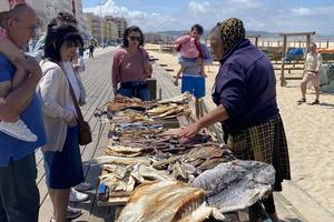 On the Nazaré boardwalk, locals and tourists alike are enticed by vendors offering all sorts of sun-dried and salted fish. (Rick Steves, Rick Steves' Europe)