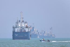 A small motorboat passes anchored vessels in the Strait of Hormuz off Bandar Abbas, Iran, on June 11, 2026. Amirhosein Khorgooi/ISNA via AP