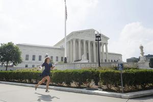 A news reporter carrying printed justice opinion announcements sprints outside U.S. Supreme Court on June 29, 2026, in Washington, DC. Tom Brenner/Getty Images