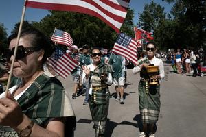 A Laotian heritage group participates in an Independence Day parade in Iowa. Communal celebrations like this can foster belonging. Scott Olson/Getty Images