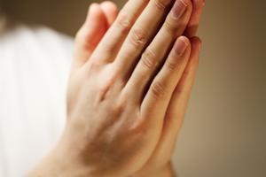 Hands clasped in a prayer. Dreamstime/TCA