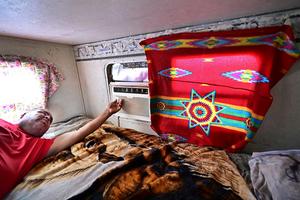 Elbert Yazzie adjusts his air conditioning unit in Tuba City, Ariz., in 2025. Frederic J. Brown/AFP via Getty Images