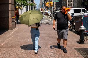 People try to stay cool on the sweltering streets of Manhattan during a heat wave in July 2025. Spencer Platt/Getty Images