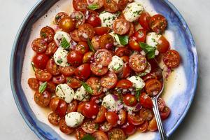 A bright salad with cherry tomatoes, fresh basil, and tiny pearls of mozzarella, tossed together with a zippy dressing. (Ryan Liebe/TCA)