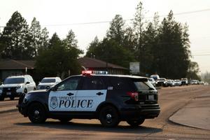 Police create evacuation corridors to quickly move vehicles out of a neighborhood threatened by a wildfire on Aug. 1, 2026. AP Photo/Young Kwak