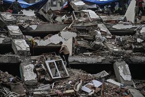 A man walks amid debris of buildings damaged by the June 24 earthquakes, in Tanaguarena, state of La Guaira; Venezuela, on July 18, 2026. The twin earthquakes that struck Venezuela last month killed over 5,000 people, officials said, while announcing they drew hundreds of millions of dollars from the International Monetary Fund (IMF) for reconstruction. (Photo by Juan BARRETO / AFP via Getty Images)