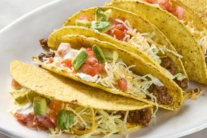 Hard-shell tacos with taco-spiced filling, shredded cheese, lettuce and sour cream. (Alex Lepe/TCA)