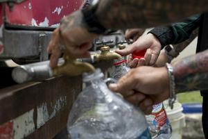 Residents collect water from a tanker truck amid government-imposed water rationing in San Juan, Puerto Rico, in August 2026. Ricardo Arduengo/AFP via Getty Images