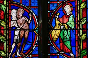 Adam and Eve - Stained Glass in Tours Cathedral. Stained glass window depicting Adam and Eve in the Cathedral of Tours, France. Dreamstime/TCA
