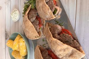 Enjoy smashed lamb burgers tucked into warm pita, served with sweet corn and creamy cucumber whipped feta. (JeanMarie Brownson/TCA)