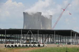 The cooling towers of an electric station are seen beyond an Amazon Web Services data center construction project in Berwick, Pa. Paul Weaver/SOPA Images/LightRocket via Getty Images
