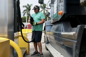 With fuel prices at record highs, a truck driver prepares to pump diesel into a tractor trailer at a gas station in Florida. Joe Raedle/Getty Images