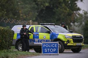Armed police man a roadblock while posted outside RAF Fairford base in Fairford, south-west England on September 27, 2026, as UK counter-terrorism police investigate an incident near the base in the village of Whelford. British police on September 27 declared a major incident and evacuated villagers living near a base used by the US air force after arresting several men on suspicion of explosives offences. (Photo by JUSTIN TALLIS / AFP via Getty Images)