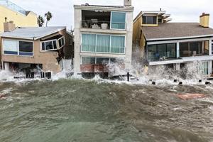 Waves crash into damaged homes in Long Beach, Calif., amid high surf generated by Tropical Storm Rachel on Oct. 11, 2026. Mario Tama/Getty Images